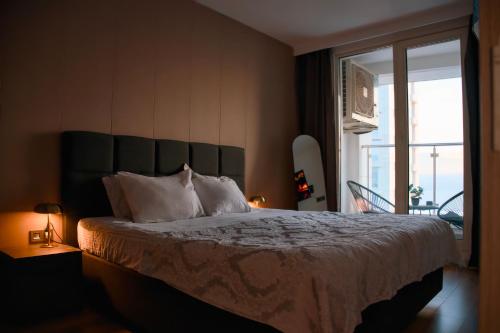 a bedroom with a large bed with a large window at Stellarlux Apartment, 35th floor in Skopje
