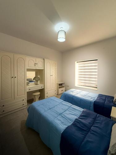 a bedroom with two beds and a desk and a sink at Bright Modern Apartment with Rooftop in Mqabba