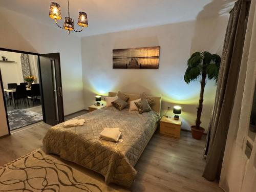 a bedroom with a bed and a potted tree in it at Apartment PMH in Veľká Mača