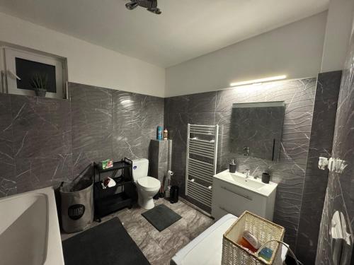 a bathroom with a tub and a toilet and a sink at Apartment PMH in Veľká Mača