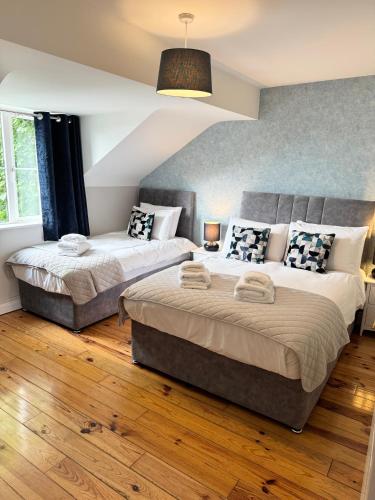 two beds in a bedroom with wooden floors at Kerry Holiday Homes at the Killarney Holiday Village in Killarney