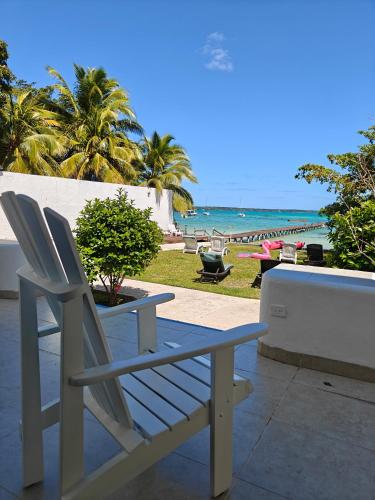 a bench and a table and chairs on the beach at Departamentos Blue Bacalar in Bacalar