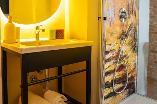 a yellow bathroom with a sink and a shower at Casa Rachele alloggio turistico in Sabina in Poggio Mirteto