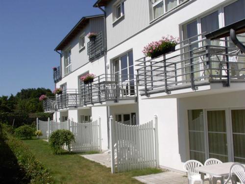 a white building with a white fence and chairs at Ferienwohnung 7 Katharina mit Balkon in Lauterbach