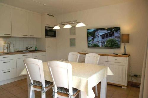 a kitchen with a dining table and white chairs at Ferienwohnung 7 Katharina mit Balkon in Lauterbach