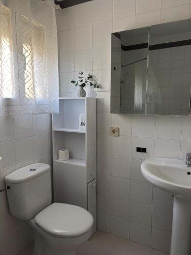 a white bathroom with a toilet and a sink at La Alcazaba de Cristina in El Puerto de Santa María