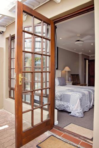 a door leading into a bedroom with a bed at Bayside Guesthouse in Port Elizabeth