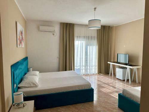 a hotel room with a bed and a television at Hotel Amaiià in Sarandë