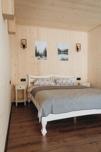 a bedroom with a large bed and two pictures on the wall at Veranda Rozhanka in Verkhnyaya Rozhanka
