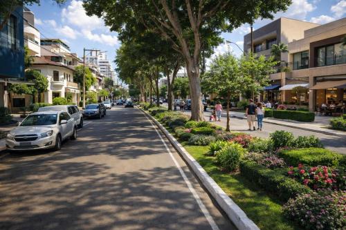 a city street with parked cars and people walking down the street at Copacabana Stay in Serra