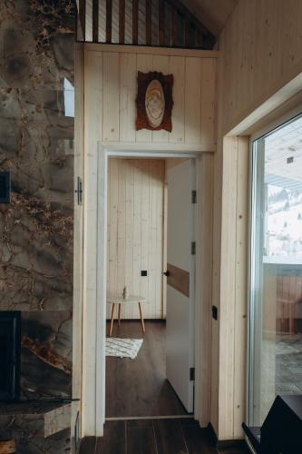 a room with a door and a clock on the wall at Veranda Rozhanka in Verkhnyaya Rozhanka