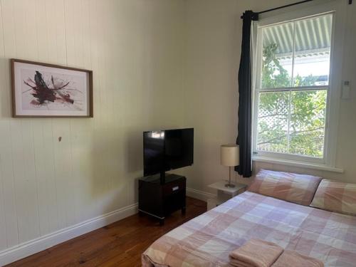 a bedroom with a bed and a flat screen tv at Gabba Beautiful rooms in Brisbane