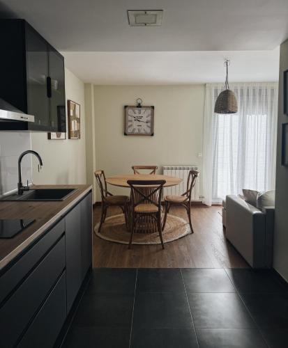 a kitchen and living room with a table and chairs at El Mirador del Susarón in Puebla de Lillo