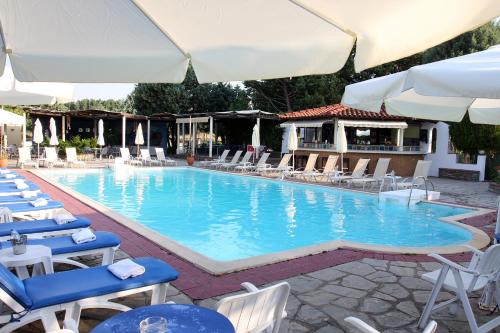 a large swimming pool with chairs and umbrellas at Hotel Galaxy in Krepeni