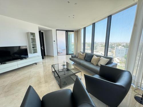 a living room with a couch and a television at SkyHigh Park View Residence in Nicosia