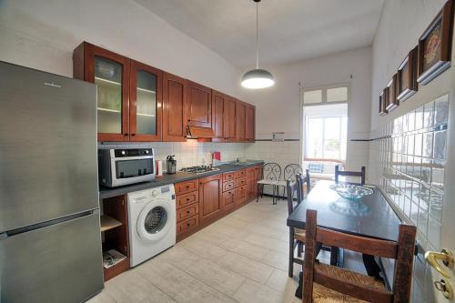 a kitchen with a refrigerator and a table with chairs at Lemon Home in Olbia