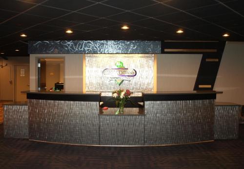 a lobby with a bar with a vase of flowers at Hotel at Batavia Downs in Batavia