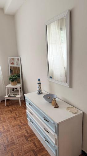 a white dresser with a mirror on the wall at A beira do Mar in Bueu