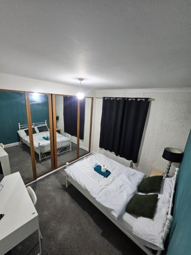 a bedroom with a large bed and a mirror at Stylish Guest House in heart of Dartford Central in Dartford