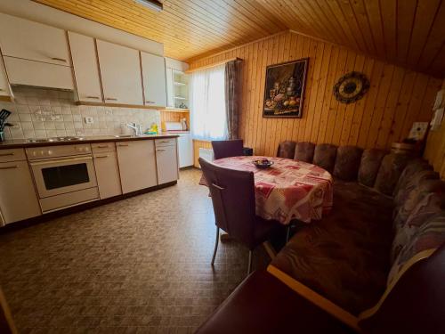 a kitchen with a table and a kitchen with a table and chairs at Staldenried Ferienwohnung in Staldenried