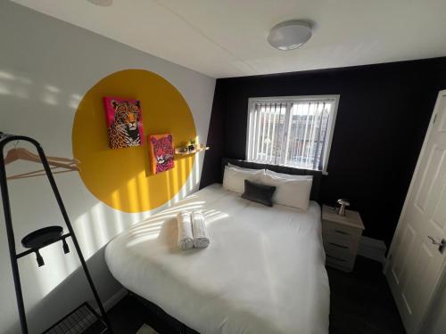 a bedroom with a white bed with a yellow circle on the wall at 8 person 4 bedroom 4en-suite Free Parking in Warwick