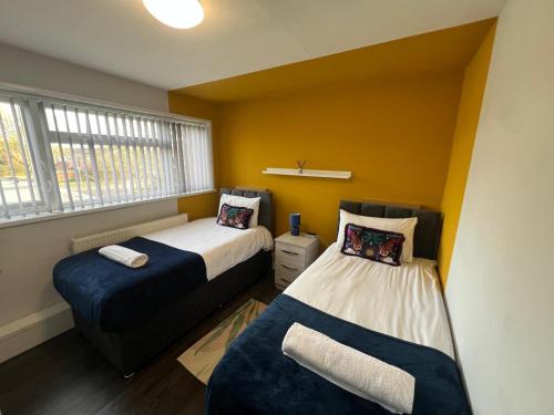 a bedroom with two beds and a window at 8 person 4 bedroom 4en-suite Free Parking in Warwick