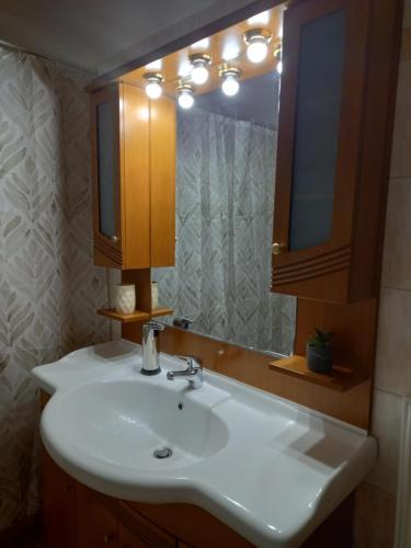 a bathroom with a white sink and a mirror at Marbi Apartment in Tripoli