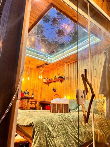 a bedroom with a bed in a wooden wall at Cabana da Árvore e Cabana Retrô - ForestPlace in Monte Verde