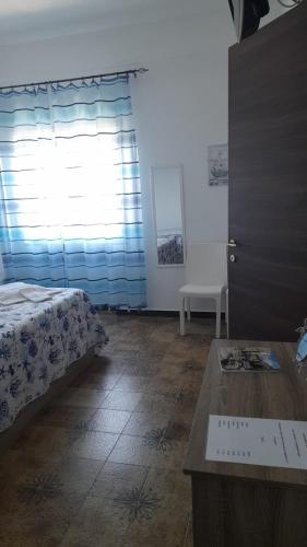 a bedroom with a bed and a table and a window at B&B Don Orlando in Pizzo