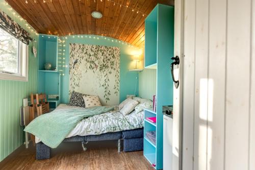 a bedroom with a bed and a wooden ceiling at The Hideaway at Duffryn Mawr Self Catering Cottages in Cowbridge