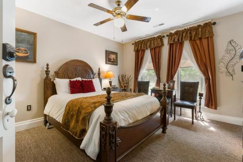 a bedroom with a bed and a ceiling fan at Dreams2Reality | Historic Branson Hotel - Notebook Room - Downtown in Branson