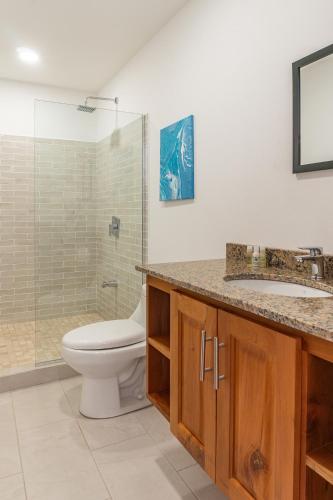 a bathroom with a toilet and a sink and a shower at Residencias Samara in Sámara