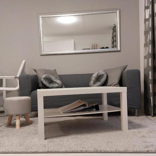 a living room with a couch and a mirror at Wohnung an der Lagune in Büsum