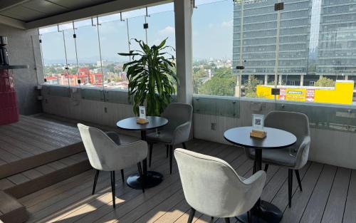 a balcony with two tables and chairs and a plant at Hot Elite - Love Hotel - Solo Adultos in Mexico City