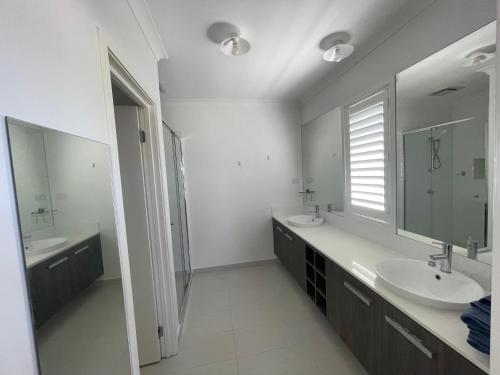 a white bathroom with two sinks and a mirror at Master's bedroom in Mount Duneed in Mount Duneed