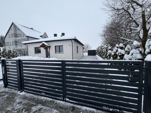 a fence in front of a house with snow at Klimatyczny Dom in Zamość