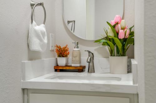 a bathroom with a sink with flowers and a mirror at Great for Digital Nomads! Convenient Manteca Apt in Manteca