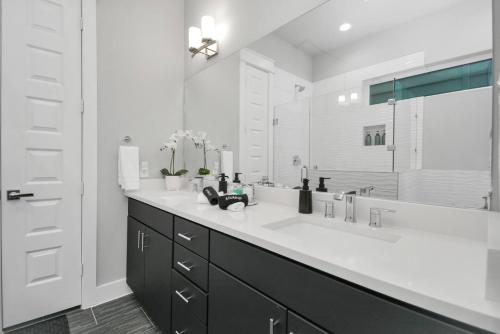 a bathroom with a sink and a large mirror at Mohr Haus - Walk to NRG Stadium - Medical Center - Sleeps 8 in Houston