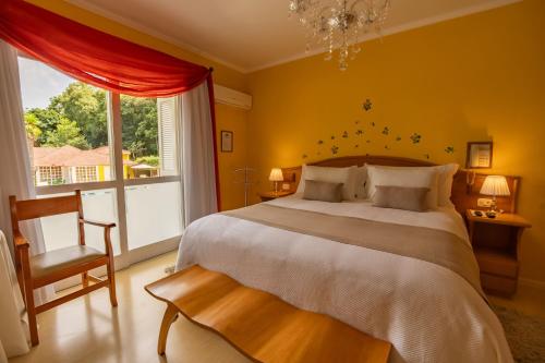 a bedroom with a large bed and a large window at Hotel Pousada da Neve in Nova Petrópolis