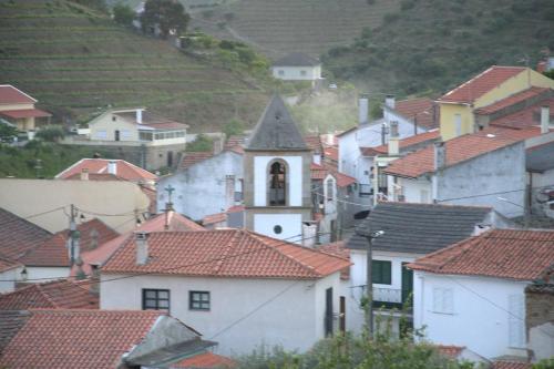 eine Gruppe von Häusern mit einer Kirche in einer Stadt in der Unterkunft EiraDouro Casa Amendoeira in Mós