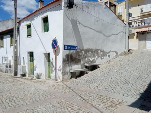 eine Straße mit einem Straßenschild neben einem Gebäude in der Unterkunft EiraDouro Casa Amendoeira in Mós
