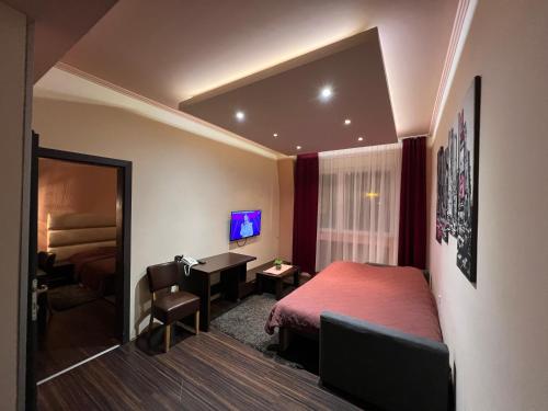a hotel room with a bed and a desk at Hotel Petrus in Paraćin
