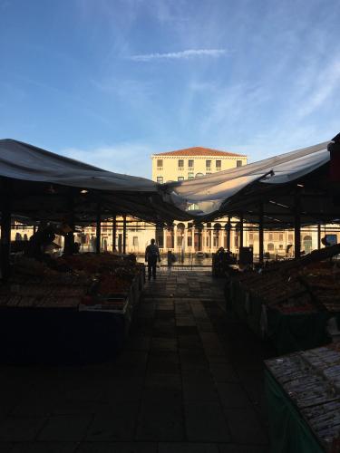 a person walking through a market with a large tent at Antico Mercato in Venice