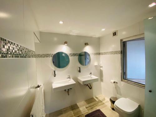 a bathroom with two sinks and a toilet at Sands in St. Julianʼs