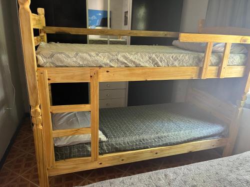 a wooden bunk bed with two sets of bunk beds at Casa Vidro Mar in Bombinhas