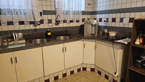 a kitchen with white cabinets and a sink at Mendes Residence in Belém