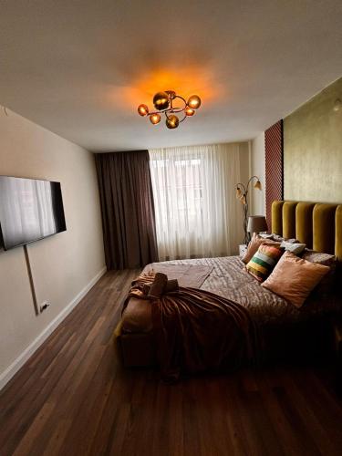 a bedroom with a bed and a chandelier at GZP Residence Lugoj 21 in Lugoj