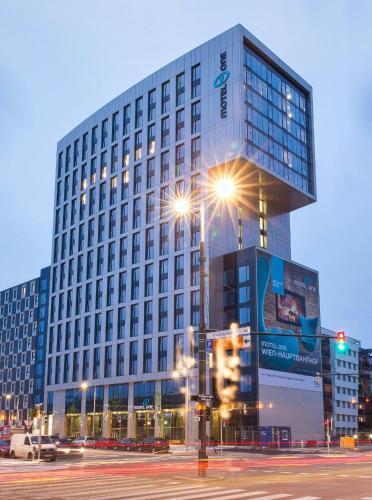 a tall building with lights in front of it at Motel One Wien-Hauptbahnhof in Vienna