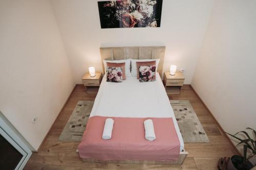 a bedroom with a large bed with two lamps at Apartament Andreas - centru, confort si relaxare in Arad