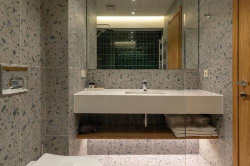 a bathroom with a sink and a mirror at MontiSio Boutique Hotel in Gudauri